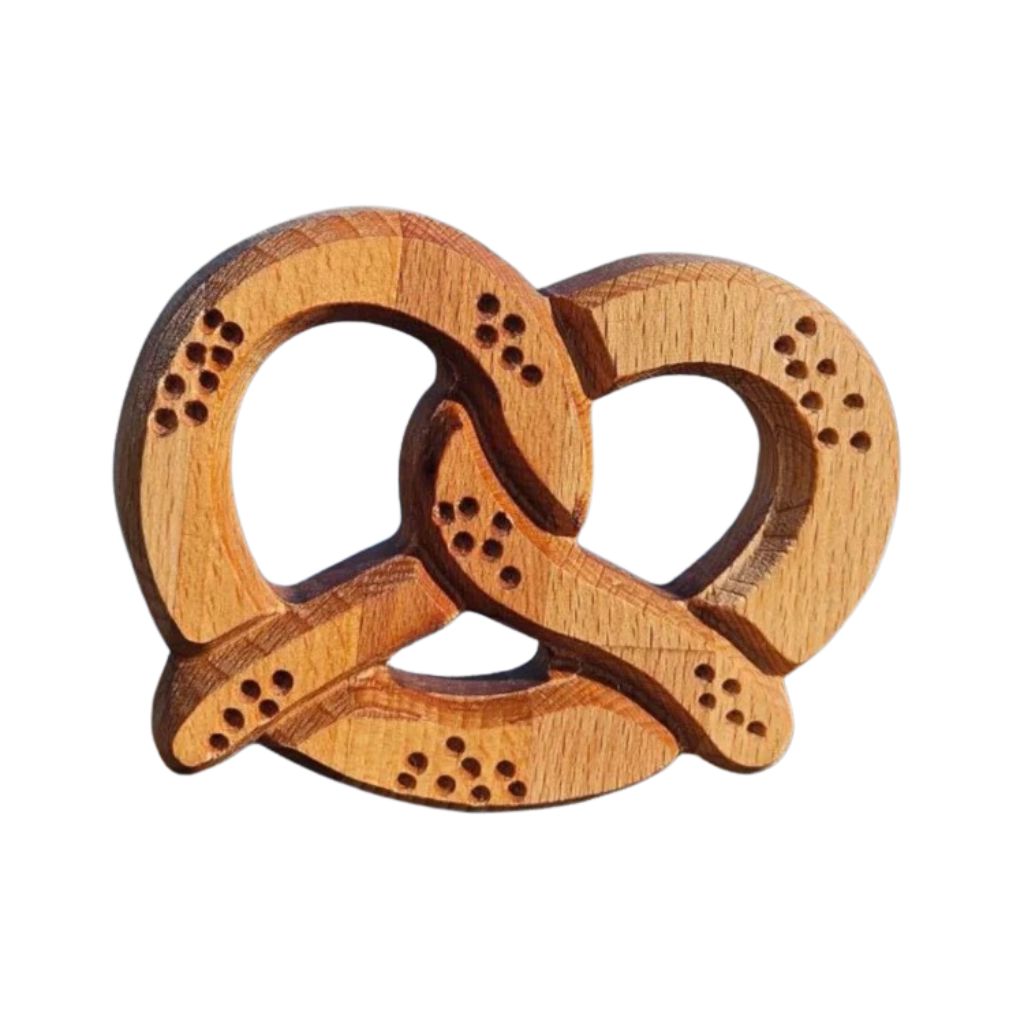 Petit bretzel alsacien en bois naturel Bretzheim, dessous de verre artisanal avec détails ajourés.